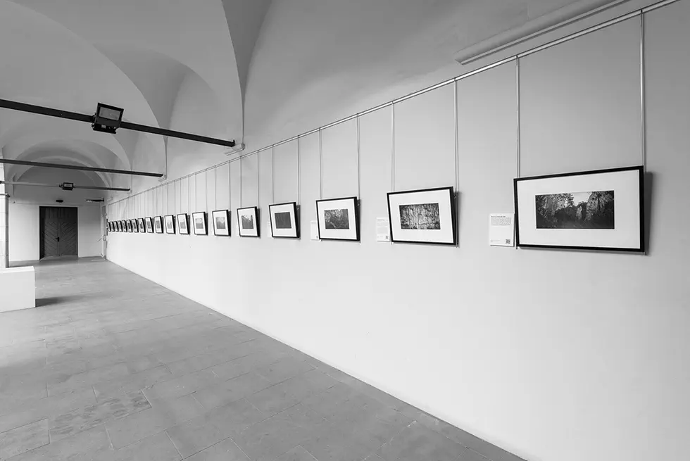 Photographs displayed in a long corridor with arched ceilings.