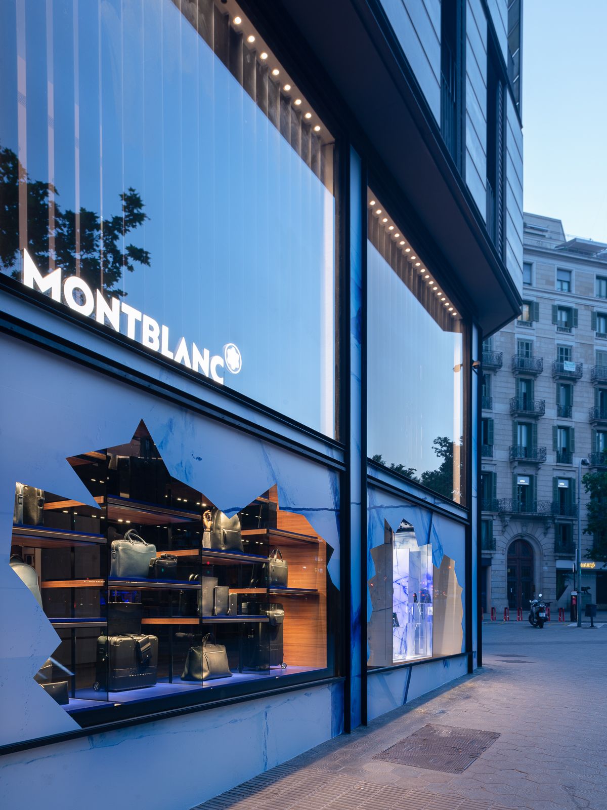 Primer pla dels aparadors amb temàtica de glacera de la botiga Montblanc amb prestatges il·luminats mostrant productes de luxe.
