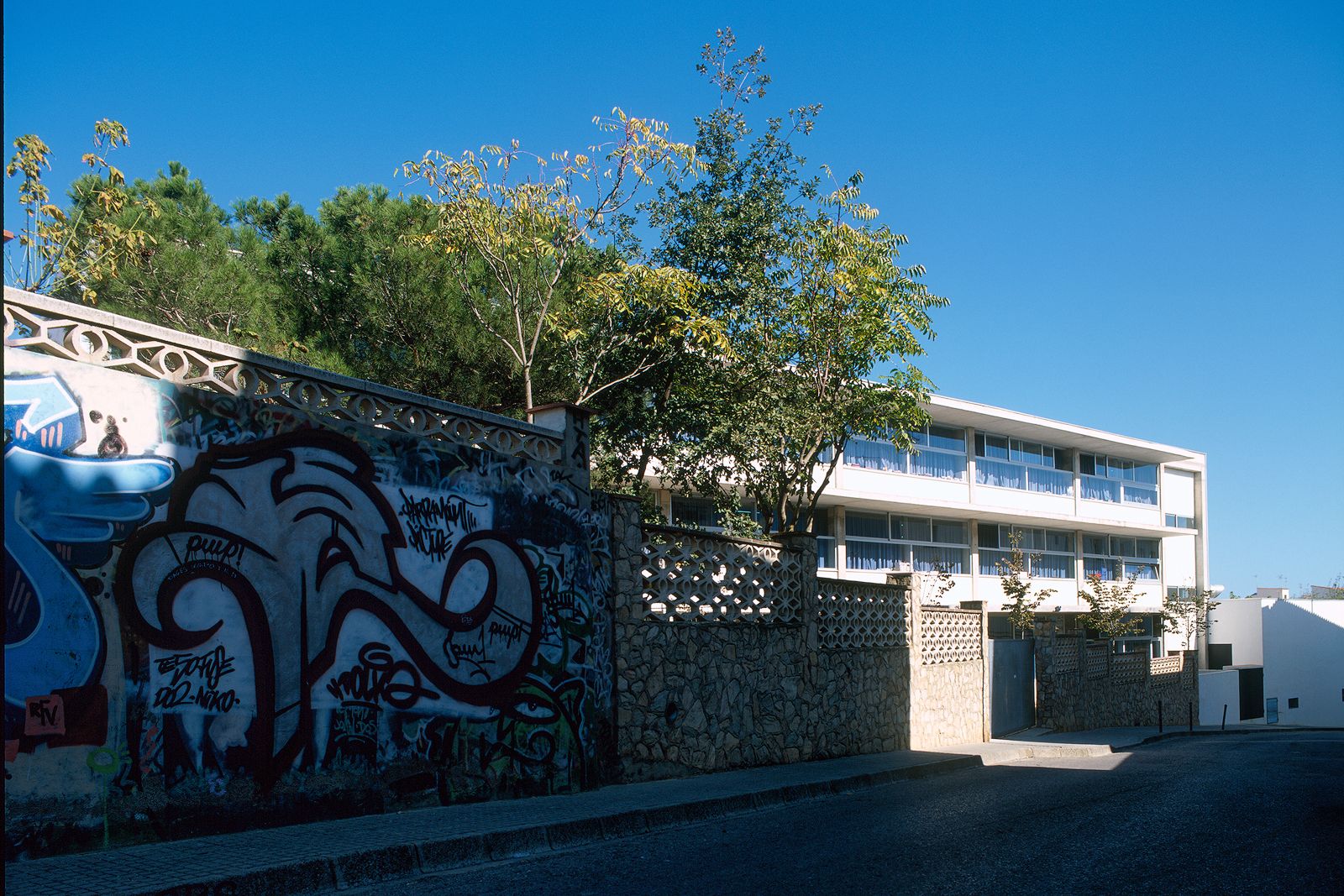 School building with a graffiti-decorated wall in the foreground.