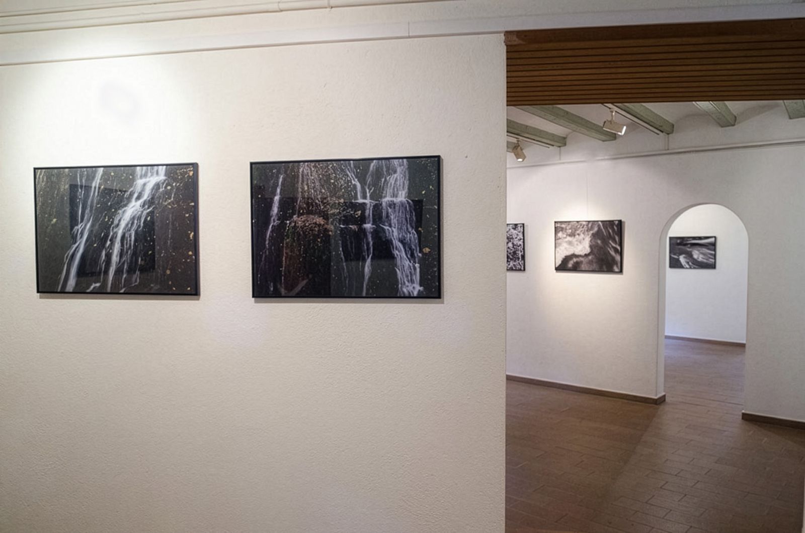 Tres salas de galería en enfilada, con fotografías de cascadas en cada una de ellas.