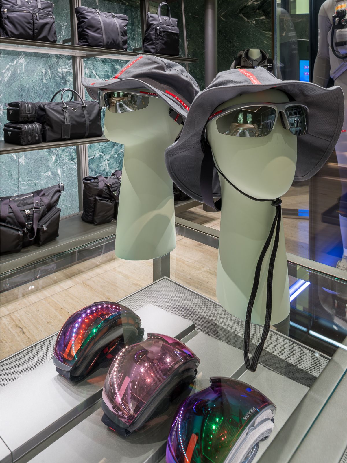 Boutique de luxe Prada, una taula de vidre mostra ulleres, barrets i ulleres de rendiment per esquiar.