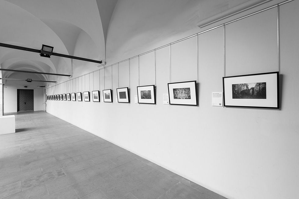 Photographs displayed in a long corridor with arched ceilings.