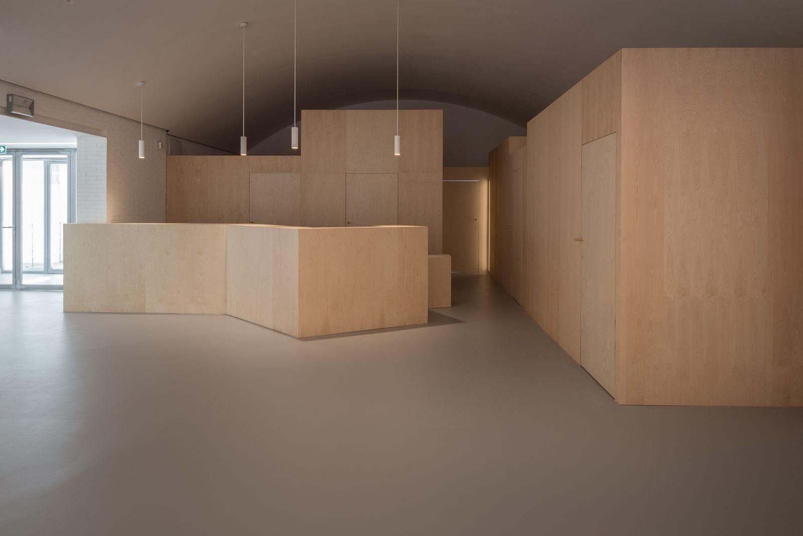 Modern interior featuring geometric wooden structures and minimalist pendant lighting.