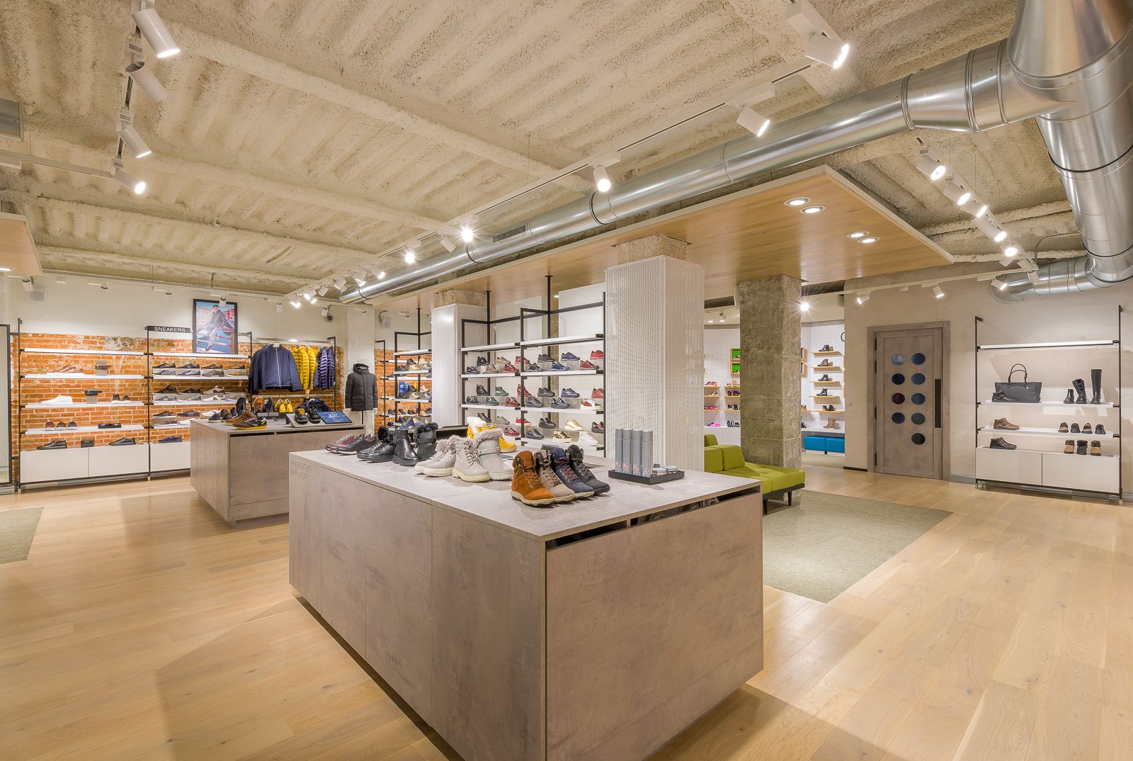 Interior of Geox store, showcasing a modern, well-lit space with shoes and jackets neatly displayed on shelves and tables.