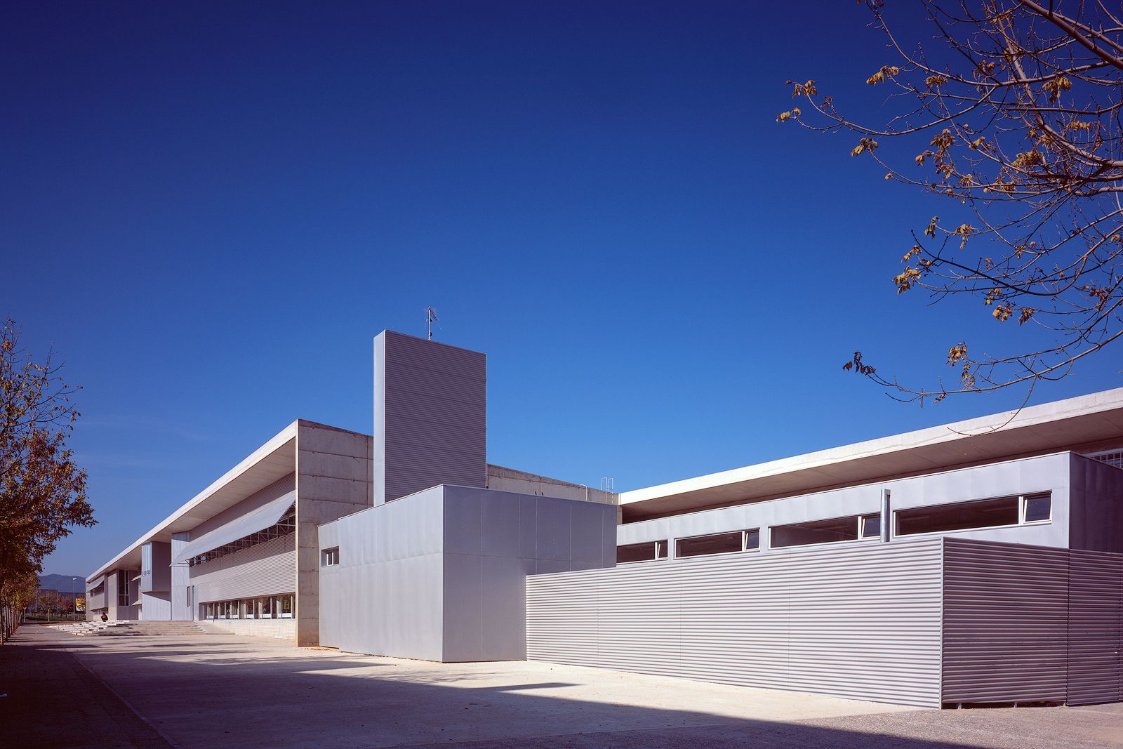 Exterior view showing a modern architectural design with clean lines and large windows under a clear blue sky.