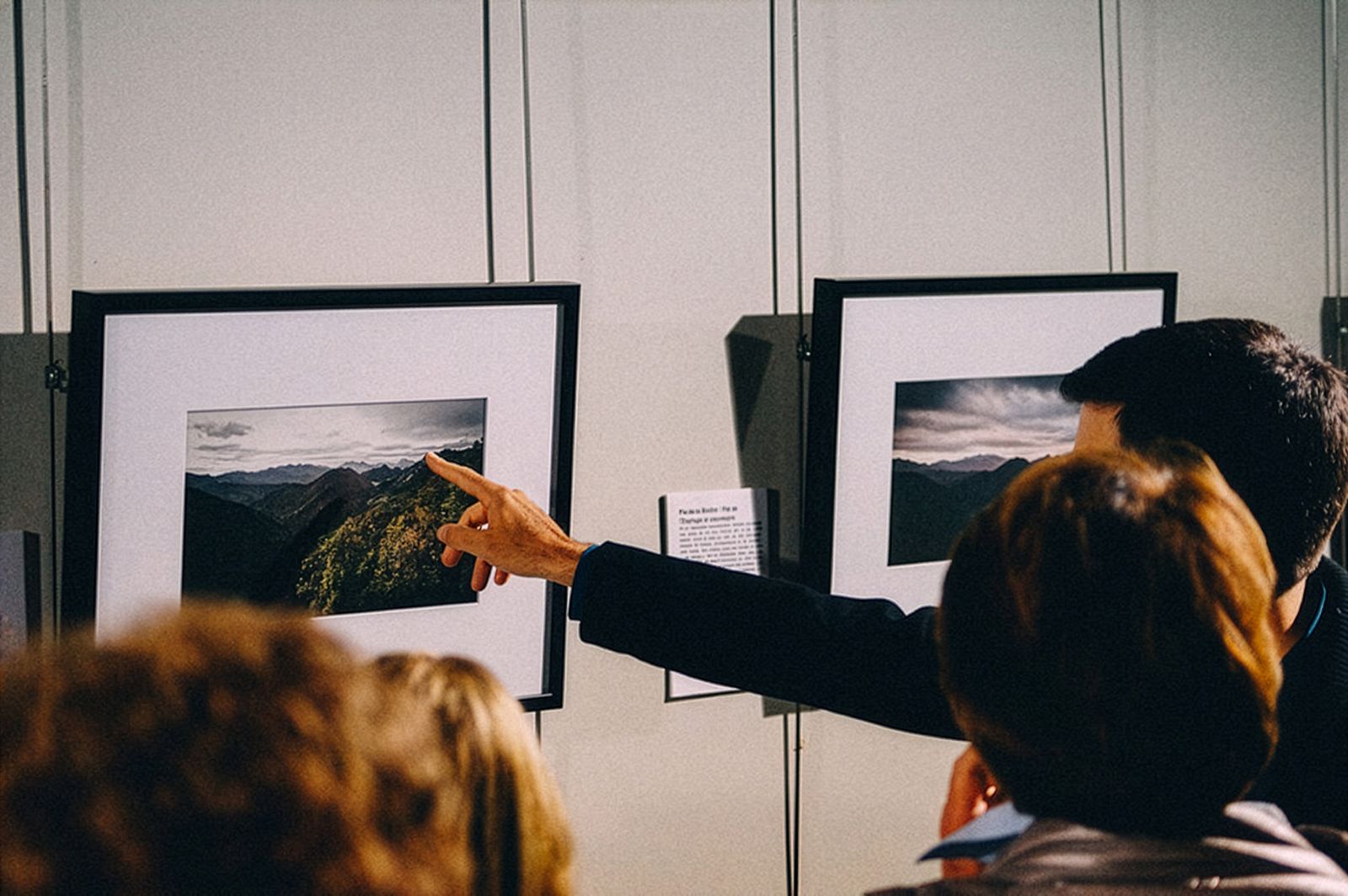 Un hombre señalando una fotografía mientras la explica a un grupo de personas.